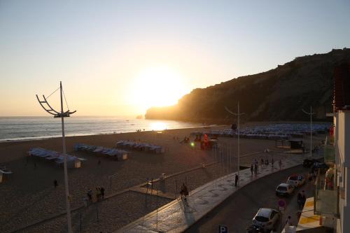 uma praia com uma multidão de pessoas e o oceano em Feel Nazaré - Ocean View na Nazaré