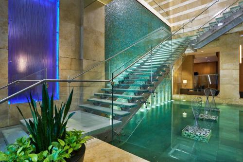 a swimming pool with a glass staircase in a building at The Westin Virginia Beach Town Center in Virginia Beach