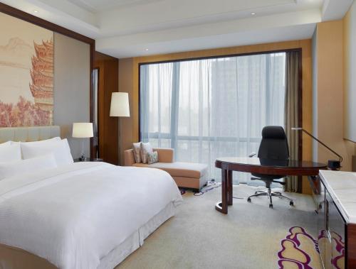 1 dormitorio con 1 cama grande, escritorio y escritorio en The Westin Wuhan Wuchang, en Wuhan