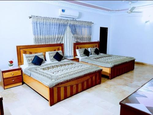 Galaxy Inn Guest House في كراتشي: غرفة نوم بسريرين ونافذة