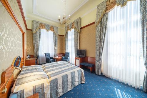 una camera d'albergo con letto, TV e finestre di Häcker's Hotel a Bad Ems