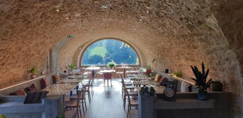 ein Esszimmer mit Tischen und Stühlen und einem großen Fenster in der Unterkunft Château De La Bûcherie in Saint-Cyr-en-Arthies