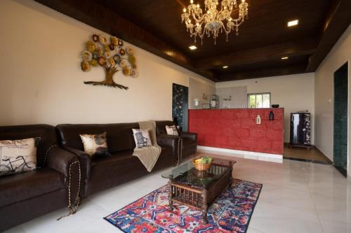 sala de estar con sofá y mesa en Lifeline Villas - Miracle 5BHK Infinity Pool Villa With Breathtaking Valley View And Huge Lawn Area, en Mahabaleshwar