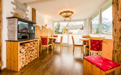 een woonkamer met een open haard en een tafel en stoelen bij Appartementhotel Zugspitzhof in Ehrwald