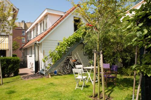 een huis met een tafel en stoelen in de tuin bij B & B Villa Suisse in Scheveningen