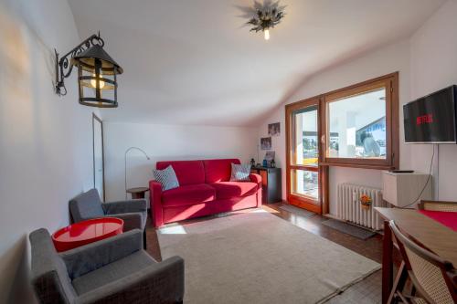 a living room with a red couch and a table at [SESTRIERE] Appartamento sulle piste in Sestriere