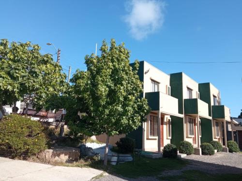 un edificio con un árbol delante de él en Cabanas Piedras Preciosas, en El Quisco