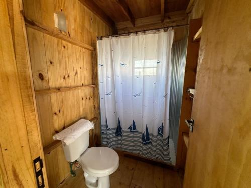 e bagno con servizi igienici e doccia con tenda. di BRASILEIRÍSSIMO POUSADA a Punta Del Diablo