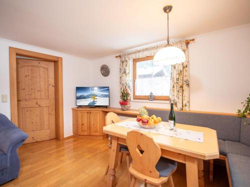 uma sala de estar com uma mesa e um sofá em apartment Johann in Wald im Pinzgau with balcony em Wald im Pinzgau