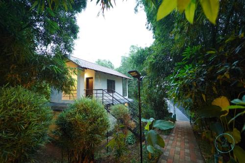 a small house with a brick walkway leading to it at Le Eden Resort in Sultan Bathery