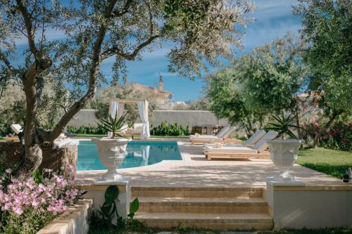 a swimming pool with two lounge chairs and a house at Nereides Luxury Villas in Káto Almirí