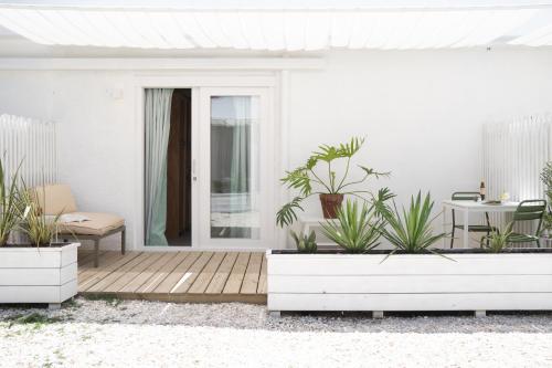 um alpendre com vasos de plantas e uma mesa em Vitaminas - Casa de Playa y Café em Punta del Este