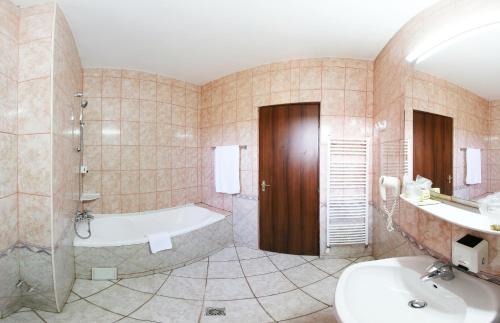 a bathroom with a bath tub and a sink at Hotel Premier in Cluj-Napoca