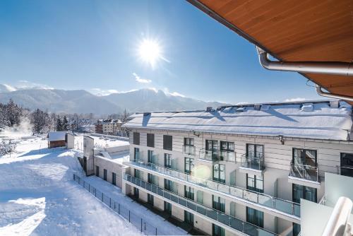 Aussicht vom Balkon eines Gebäudes im Schnee in der Unterkunft Hotel Aquarion Family & Friends - Destigo Hotels in Zakopane