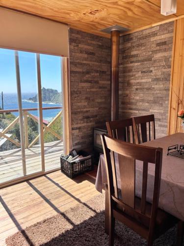 a bedroom with a bed and a view of the ocean at Cabañas Emma Maicolpue in Osorno