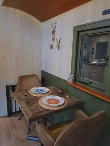 a table with two plates on it in a room at B&B 't Maartensdijkse Bos in Maartensdijk