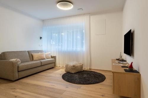 un soggiorno con divano e TV di Mountain Meadows Apt 4 a Valdaora