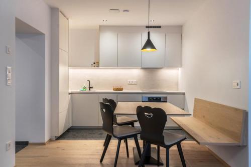 una cucina con tavolo in legno e 2 sedie di Mountain Meadows Apt 4 a Valdaora