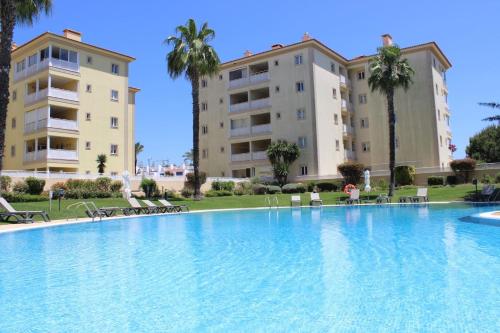 a large swimming pool in front of two buildings at Da Praia Apartment - Pool & Tenis in Vilamoura