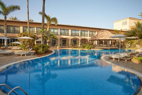 a large swimming pool in front of a hotel at Secrets Bahía Real Resort & Spa Adults only in Corralejo