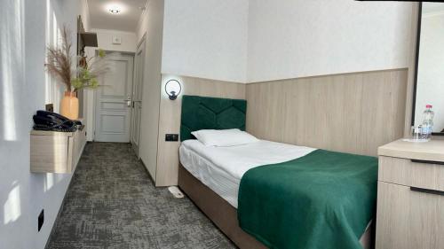 a bedroom with a bed with a green headboard at Prykarpattya in Ivano-Frankivsʼk