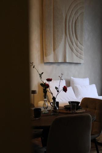 uma sala de estar com uma mesa com flores em Logies aan de Dam em Middelburg