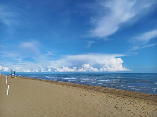 a beach with a blue sky and the ocean w obiekcie Giulio's Apartment w Bibione