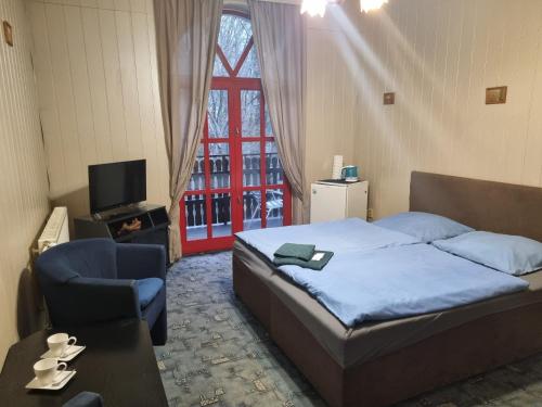 um quarto com uma cama, uma cadeira e uma janela em Studánka em Orlová