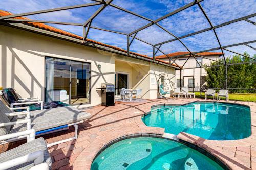 - une piscine avec une terrasse et une maison dans l'établissement Dream Villa - New 4BR/3BA - 6 Miles From Disney, à Orlando