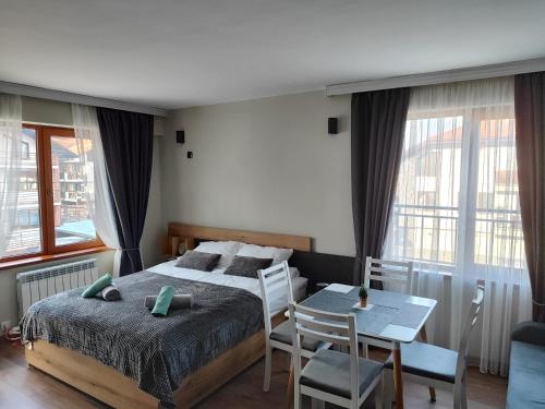 um quarto com uma cama, uma mesa e cadeiras em View apartment #2 em Bansko