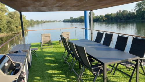 uma mesa e cadeiras num barco sobre a água em Riverboat-Rhein-Main Ferienloft em Wiesbaden