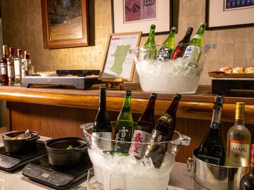 un groupe de bouteilles de vin assises sur un comptoir dans l'établissement ANA Crowne Plaza Akita, an IHG Hotel, à Akita