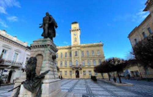 ein großes Gebäude mit einer Statue davor in der Unterkunft Monelly Apartman in Komárno