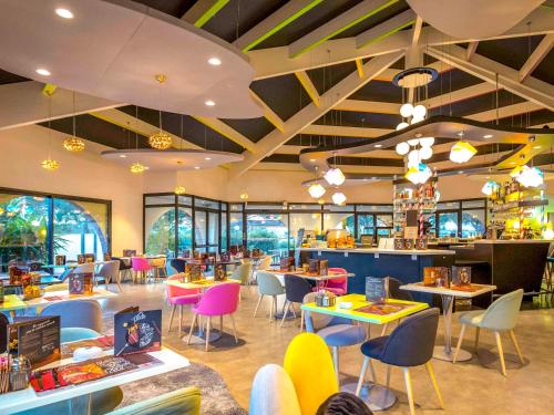 um restaurante com mesas e cadeiras e uma cafetaria em ibis Styles Fréjus St Raphael em Fréjus