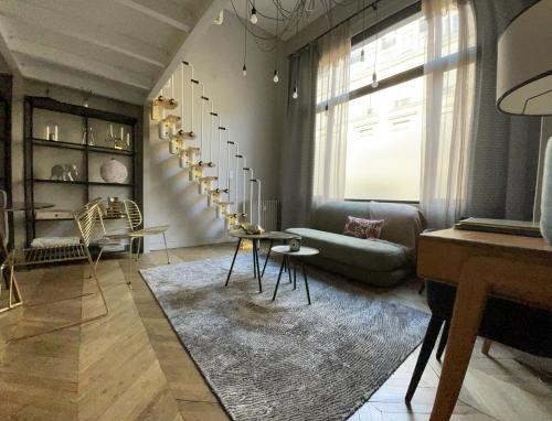 een woonkamer met een bank en een tapijt bij Loft Royal des Promenades in Reims