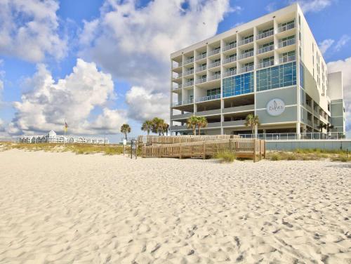 un edificio sulla spiaggia accanto a una spiaggia sabbiosa di Best Western Premier - The Tides a Orange Beach