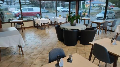 un restaurant vide avec des tables, des chaises et une fenêtre dans l'établissement Premiere Classe Geneve - Saint Genis Pouilly, à Saint-Genis-Pouilly