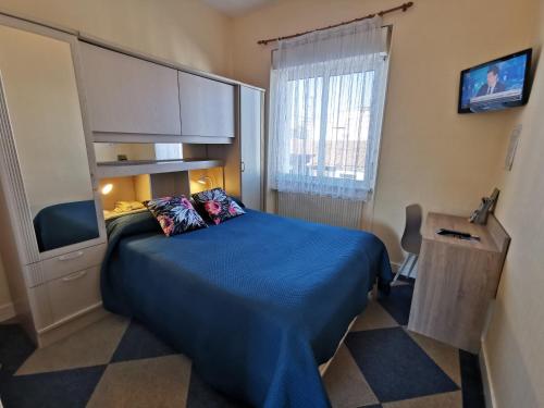 een kleine kamer met een bed en een televisie bij Hotel le Pasteur in Royan