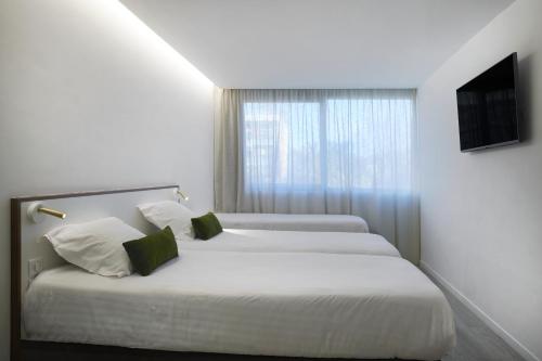 Tempat tidur dalam kamar di Hotel-Restaurant Isidore Nice Ouest