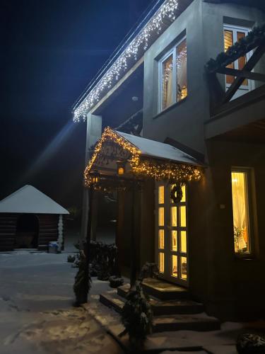 ein Haus mit Weihnachtslichtern an der Vorderseite in der Unterkunft Карпатські Зорі in Pilipets