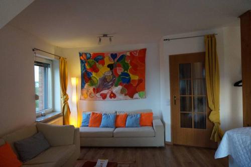 a living room with a couch and a painting on the wall at Gästewohnung von J&O am Fluss. in Jork