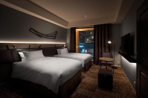 A bed or beds in a room at Nest Hotel Osaka Umeda