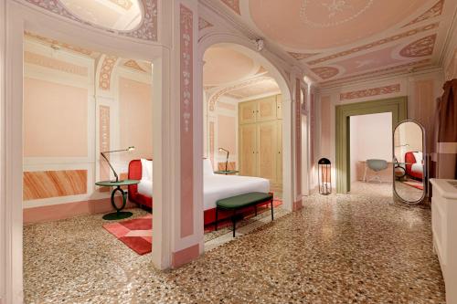 a bedroom with a bed and a room with a mirror at Palazzo Dei Fiori by Room Mate in Venice