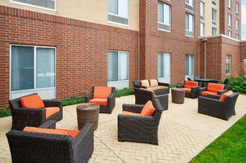 eine Gruppe von Stühlen und Tischen auf einer Terrasse in der Unterkunft Hilton Garden Inn Schaumburg in Schaumburg