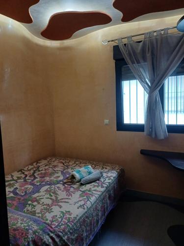 een slaapkamer met een bed met een kussen erop bij apartamento 3 corazones in Punta Umbría