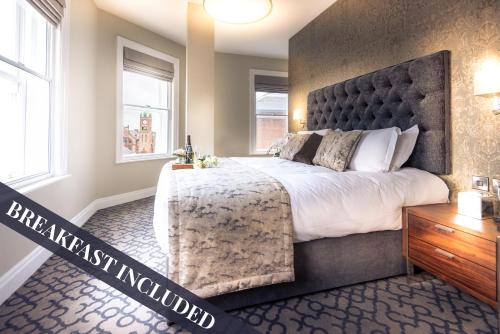 a bedroom with a large bed and two windows at Shipquay Boutique Hotel in Derry Londonderry