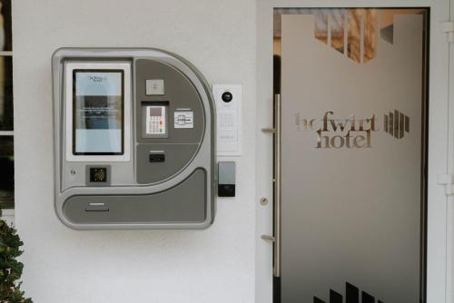 uma máquina de multibanco numa parede ao lado de uma porta em Hofwirthotel em Sankt Martin im Innkreis