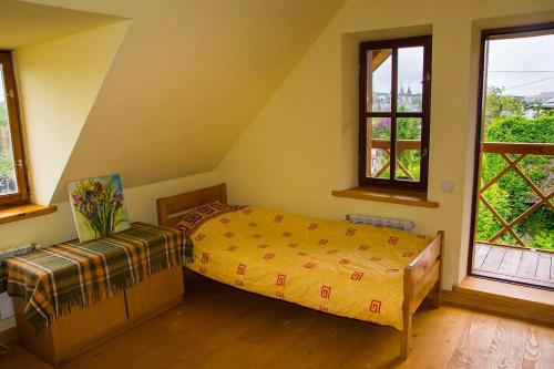 a bedroom with a bed and two windows at Tisnyi 7 Guest House in Kamianets-Podilskyi