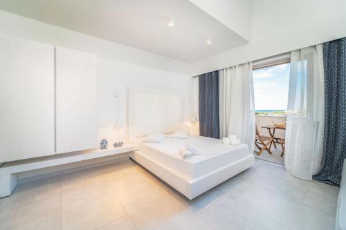 um quarto branco com uma banheira e uma grande janela em San Giovanni Beach Resort and Suites em Lefkada Town