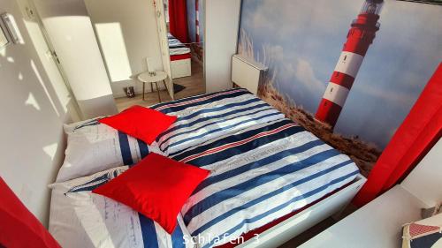 宾茨TRAUM FeWo Strandliebe mit Meerblick, 3 Schlafzimmer, 2 Bäder的一间卧室配有红色枕头的床